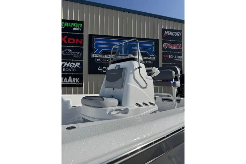 Slide: The Image of 2025 NauticStar 224 Bay boat at dealership, showcasing console and seating. - 1