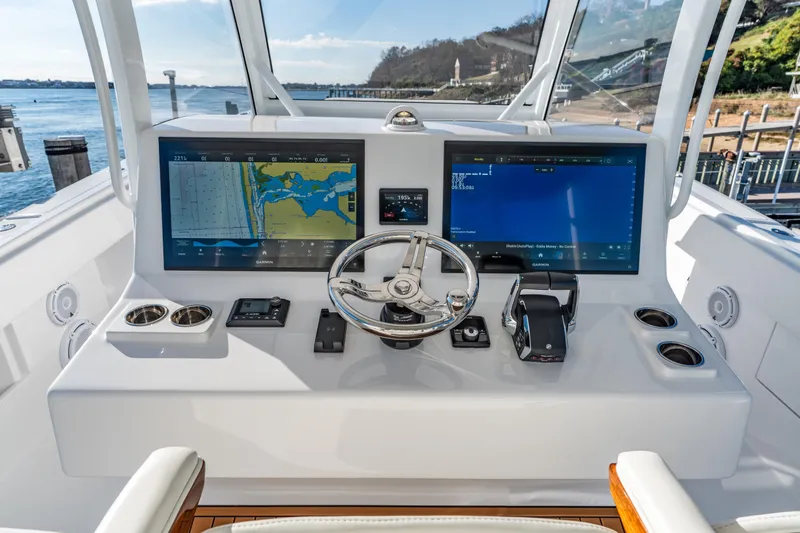 Slide: The Image of Helm of 2025 Front Runner 43 Catamaran with dual navigation screens and steering wheel. - 16