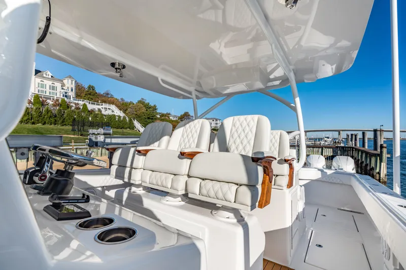 Slide: The Image of Luxurious 2025 Front Runner 43 Catamaran with plush seating and modern helm, docked by waterfront homes. - 19
