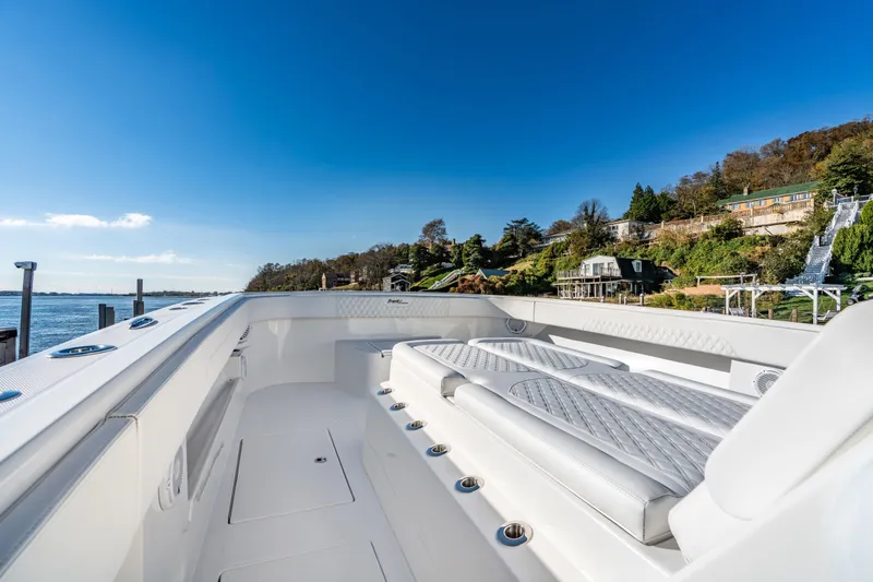Slide: The Image of 2025 Front Runner 43 Catamaran with luxurious seating, docked by scenic waterfront homes. - 22