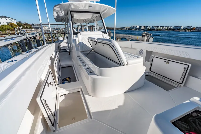Slide: The Image of 2025 Front Runner 43 Catamaran deck with open storage compartments, docked by the water. - 26