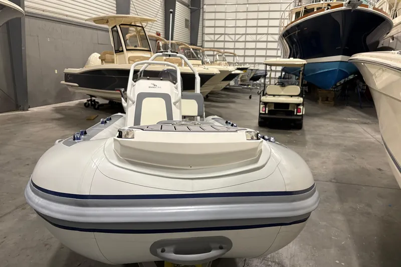 Slide: The Image of 2025 Highfield Classic 400 inflatable boat in a showroom with other vessels. - 4