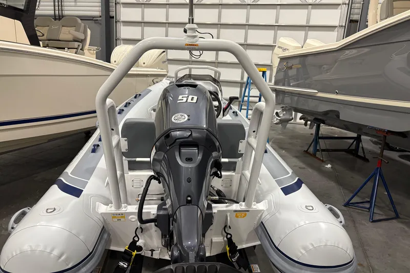 Slide: The Image of 2025 Highfield Classic 400 inflatable boat with 50 HP engine in a showroom. - 6