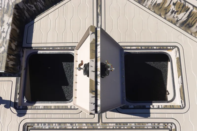 Slide: The Image of 2026 Avid 18 Commander boat storage compartments with camo design and secure latches. - 34