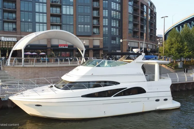 The Image of 2005 Carver 466 Motor Yacht docked near urban waterfront with modern buildings. - 0