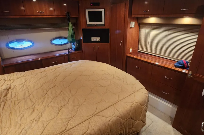 Slide: The Image of Luxurious 2005 Carver 466 Motor Yacht bedroom with wood cabinetry and cozy bedding. - 26