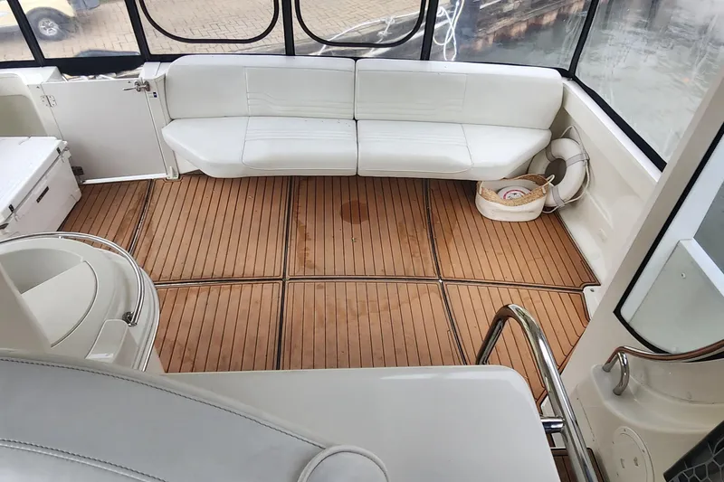 Slide: The Image of 2005 Carver 466 Motor Yacht interior with white seating and wooden flooring. - 31
