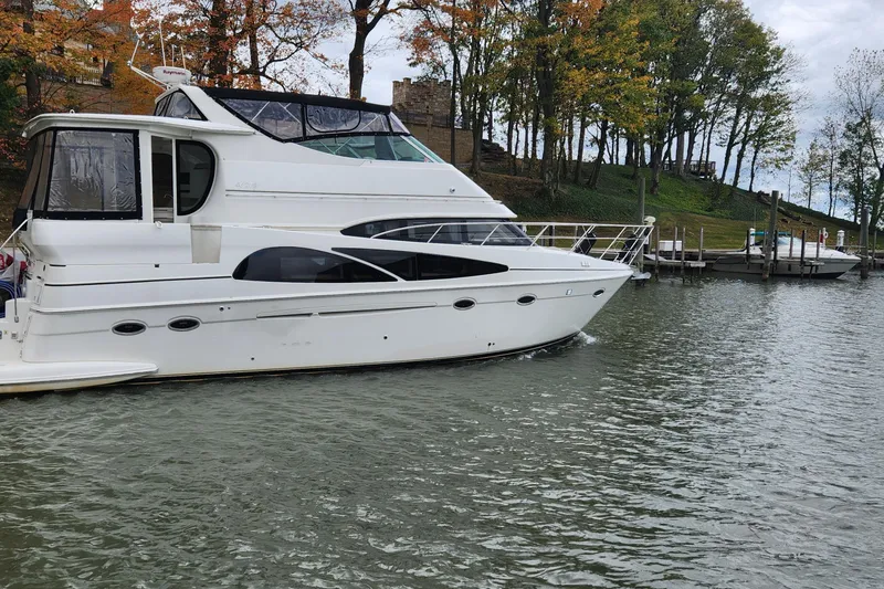 Slide: The Image of 2005 Carver 466 Motor Yacht docked on a calm lake with autumn trees. - 36