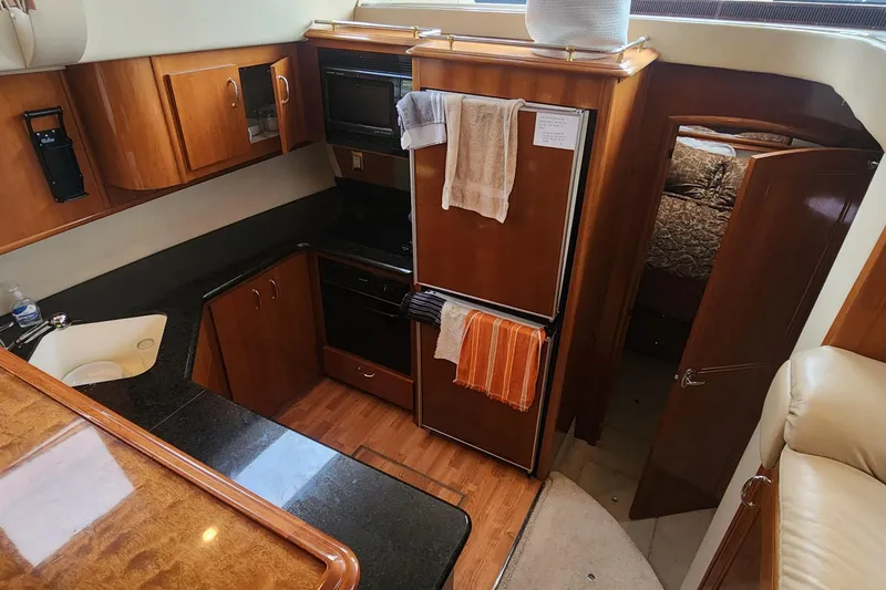 Slide: The Image of 2005 Carver 466 Motor Yacht kitchen with wood cabinetry and modern appliances. - 14