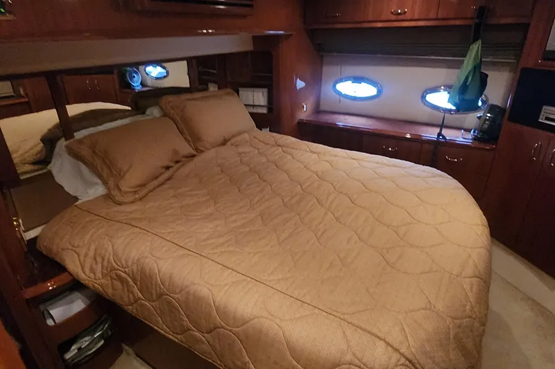 Slide: The Image of Luxurious bedroom interior of 2005 Carver 466 Motor Yacht with cozy bedding and wood cabinetry. - 25