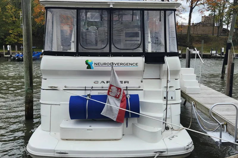 Slide: The Image of 2005 Carver 466 Motor Yacht docked, featuring "Neurodivergence" logo and Polish flag. - 33