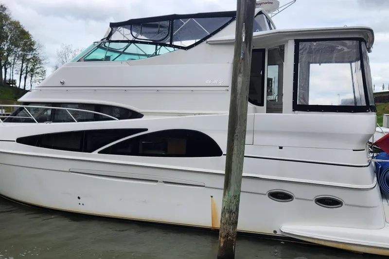 Slide: The Image of 2005 Carver 466 Motor Yacht docked, showcasing sleek design and spacious cabin. - 35