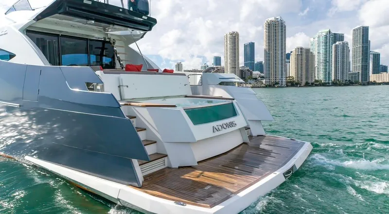 Slide: The Image of Luxury 2019 Numarine 78 yacht cruising near city skyline, featuring sleek design and spacious deck. - 16