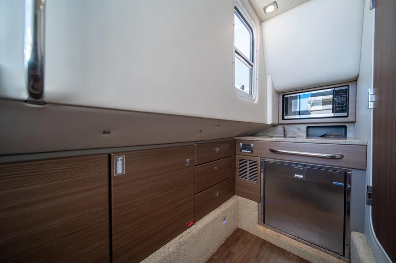 Slide: The Image of 2018 Formula 350 Crossover Bowrider OB cabin with modern kitchenette and wood finish. - 14
