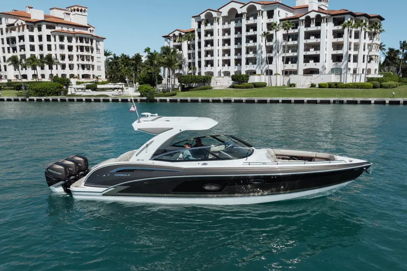 Slide: The Image of 2018 Formula 350 Crossover Bowrider OB cruising near luxury waterfront residences. - 9