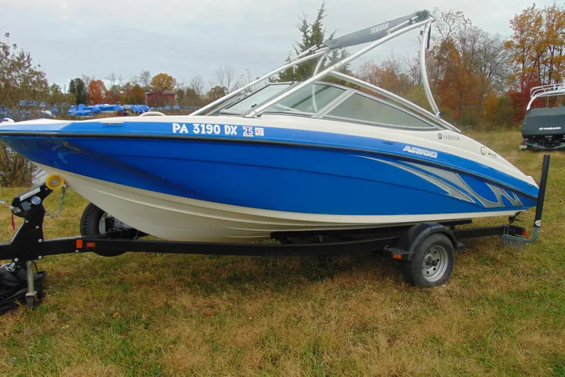 The Image of 2015 Yamaha AR190 boat on trailer, blue and white, parked on grass. - 1