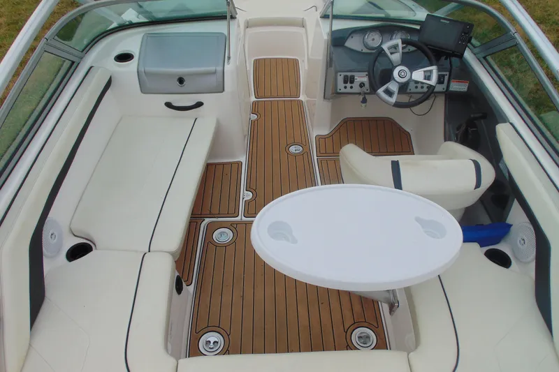 Slide: The Image of 2015 Yamaha Boats AR190 interior with wood flooring, white seating, and steering console. - 8
