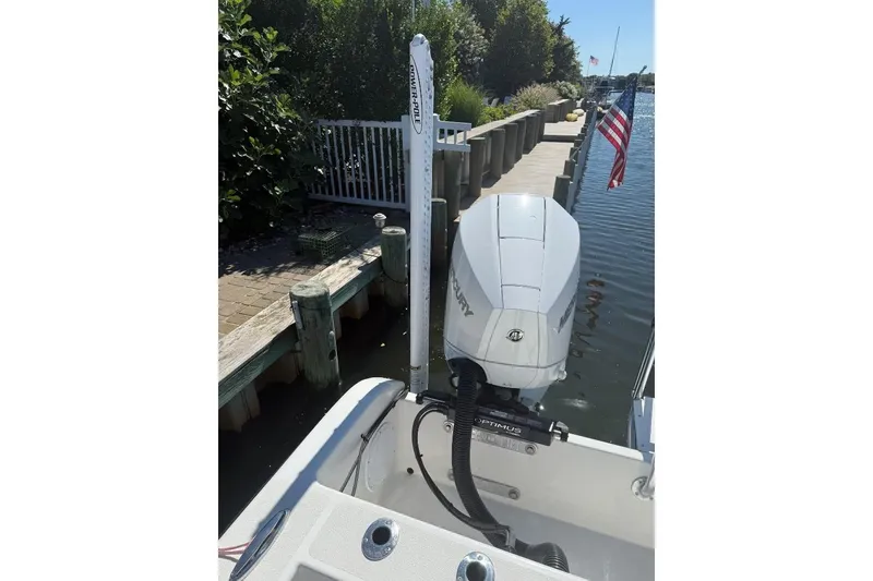Slide: The Image of 2025 Tideline 235 Hybrid boat docked, featuring Mercury outboard motor and American flag. - 14