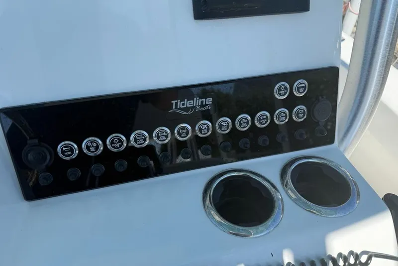 Slide: The Image of Control panel of 2025 Tideline 235 Hybrid boat with labeled buttons and cup holders. - 19