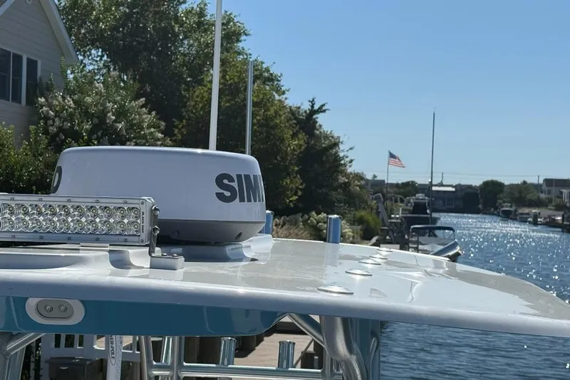 Slide: The Image of 2025 Tideline 235 Hybrid boat with radar and light bar on a sunny waterfront. - 24