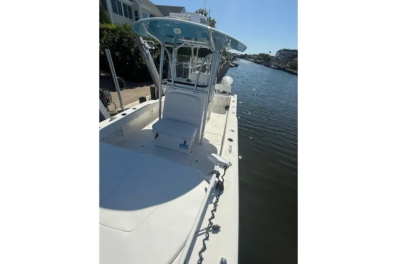 Slide: The Image of 2025 Tideline 235 Hybrid boat docked on a sunny canal, showcasing sleek design and spacious deck. - 28