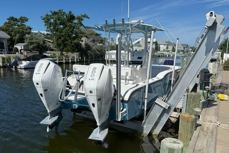 Slide: The Image of 2025 Tideline 235 Hybrid boat with dual 200 V6 engines docked by waterfront homes. - 3