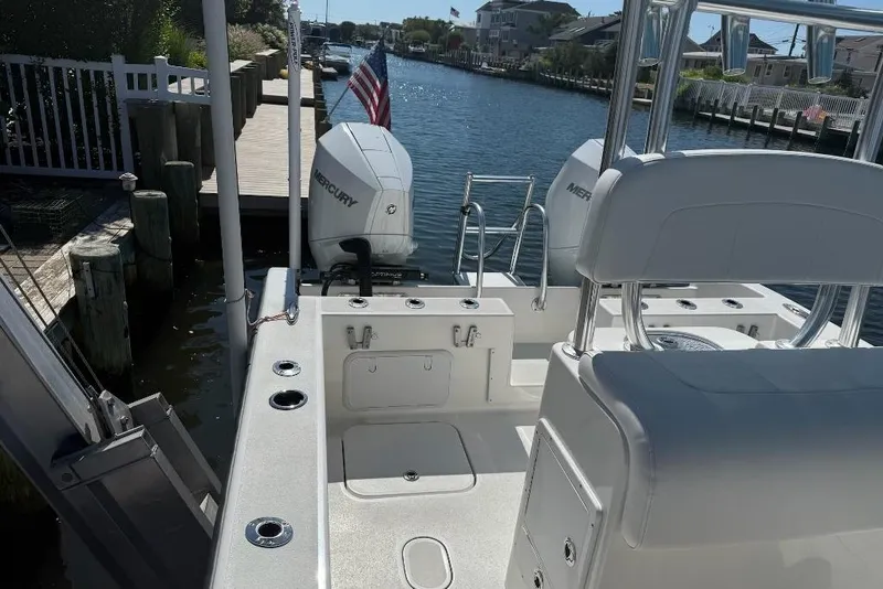 Slide: The Image of 2025 Tideline 235 Hybrid boat docked, featuring dual Mercury engines and spacious seating. - 6