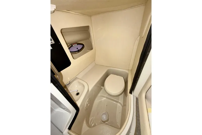 Slide: The Image of 2007 Sea Ray 290 SLX boat interior with white leather seating at a dock. - 21