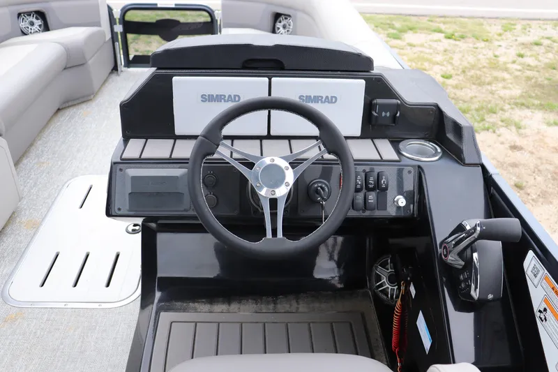 Slide: The Image of 2024 Premier 250 Solaris Rev boat dashboard with steering wheel and Simrad displays. - 6