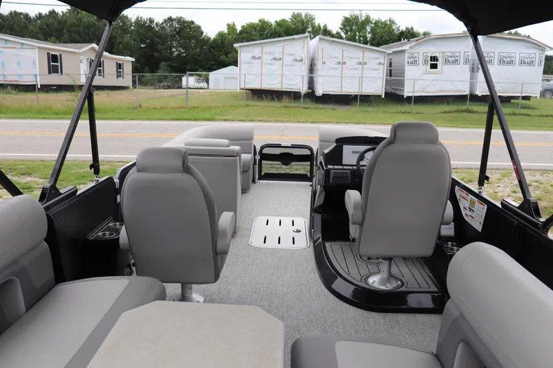 Slide: The Image of 2024 Premier 250 Solaris Rev pontoon boat interior with gray seating and modern dashboard. - 9