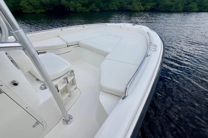 Slide: The Image of 2009 Boston Whaler 230 Dauntless boat interior with white seating, on calm water. - 11