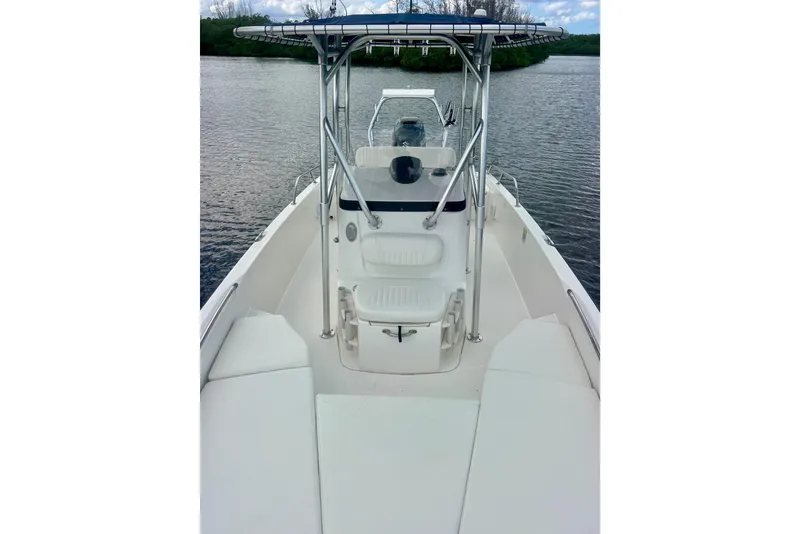Slide: The Image of 2009 Boston Whaler 230 Dauntless boat interior with seating and console on calm water. - 13