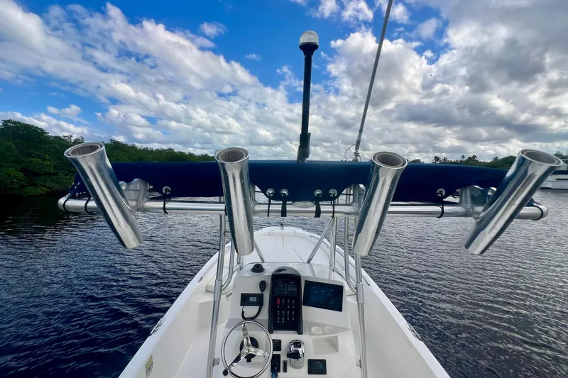 Slide: The Image of 2009 Boston Whaler 230 Dauntless boat with rod holders on a calm waterway. - 16