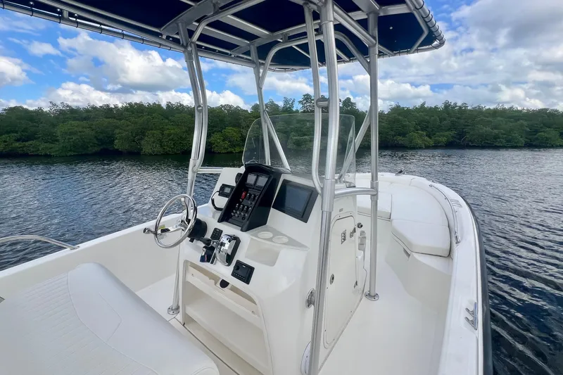 Slide: The Image of 2009 Boston Whaler 230 Dauntless boat on calm water, featuring sleek design and modern controls. - 6