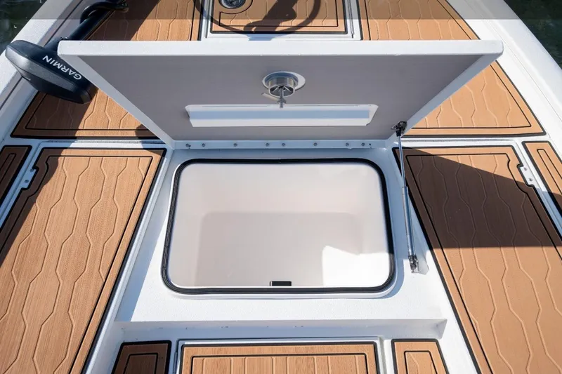 Slide: The Image of Open storage compartment on 2026 Avid 23 Mag boat deck with Garmin equipment. - 11