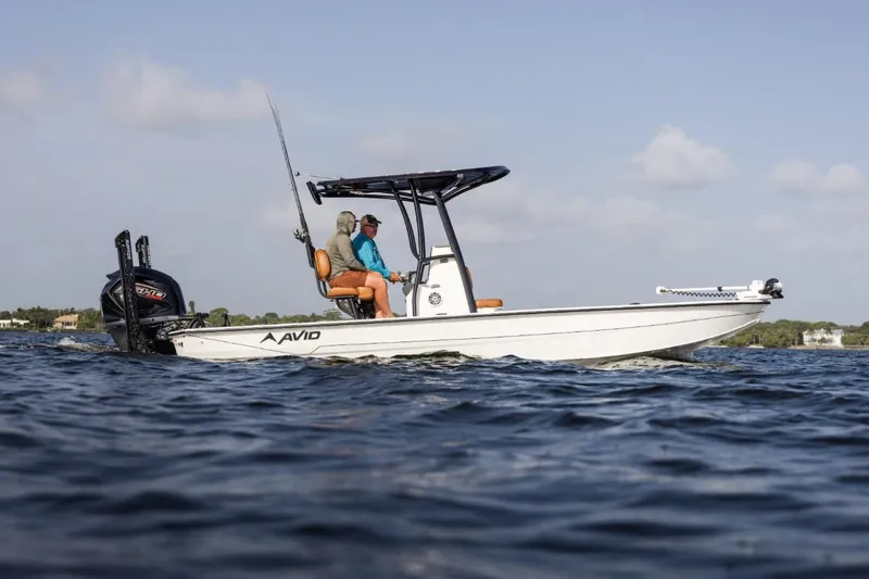 Slide: The Image of 2026 Avid 23 Mag boat cruising on open water under clear skies. - 6