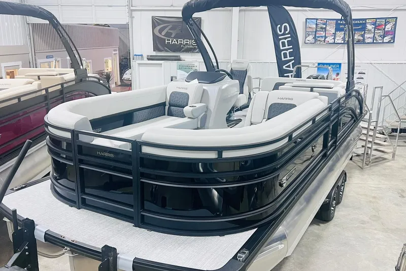 The Image of 2025 Harris Solstice 250 pontoon boat displayed in showroom with sleek design and modern features. - 0