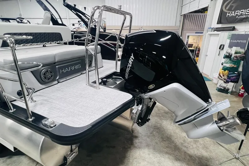 Slide: The Image of 2025 Harris Solstice 250 pontoon boat with Mercury outboard motor in showroom. - 23