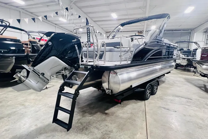 Slide: The Image of 2025 Harris Solstice 250 pontoon boat with Mercury outboard engine in showroom. - 4