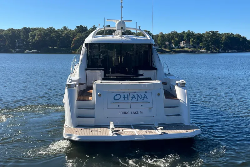 Slide: The Image of 2007 Sea Ray 60 Sundancer yacht on a serene lake, rear view. - 2