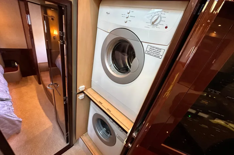 Slide: The Image of Laundry area inside 2007 Sea Ray 60 Sundancer yacht, featuring stacked washer and dryer. - 25