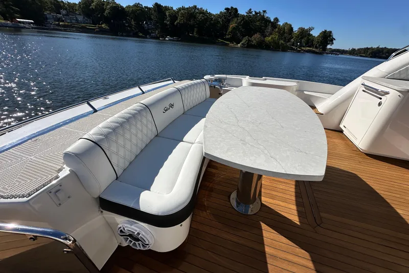 Slide: The Image of Luxurious 2007 Sea Ray 60 Sundancer yacht deck with elegant seating and table, overlooking serene waters. - 7