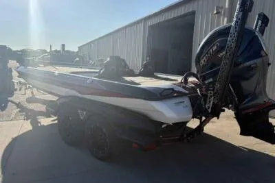 Slide: The Image of 2024 Skeeter FXR21 FLEX boat parked outside a warehouse, rear view. - 3