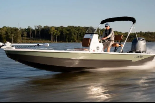 The Image of 2026 Avid 23 Fusion boat cruising on a lake with a person steering. - 1