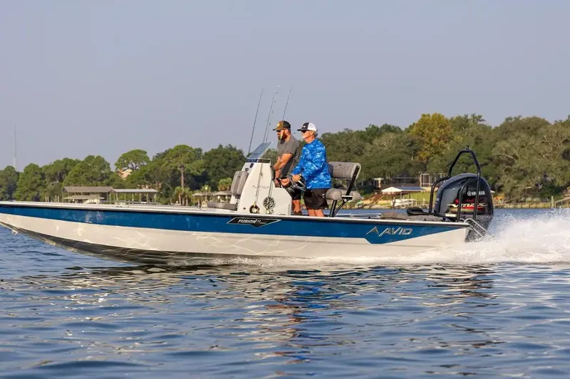 Slide: The Image of 2026 Avid 23 Fusion boat cruising on a lake with two people onboard. - 8