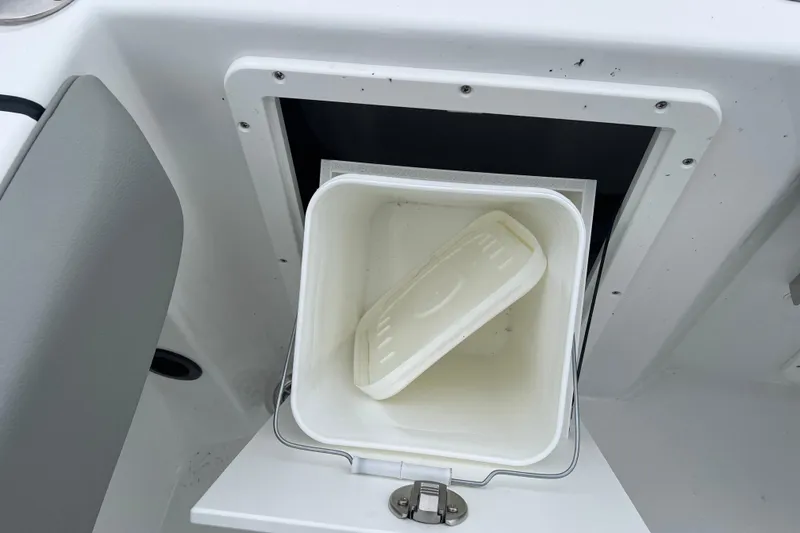 Slide: The Image of Storage compartment with a white container on a 2026 Cape Horn 22 OS boat. - 15