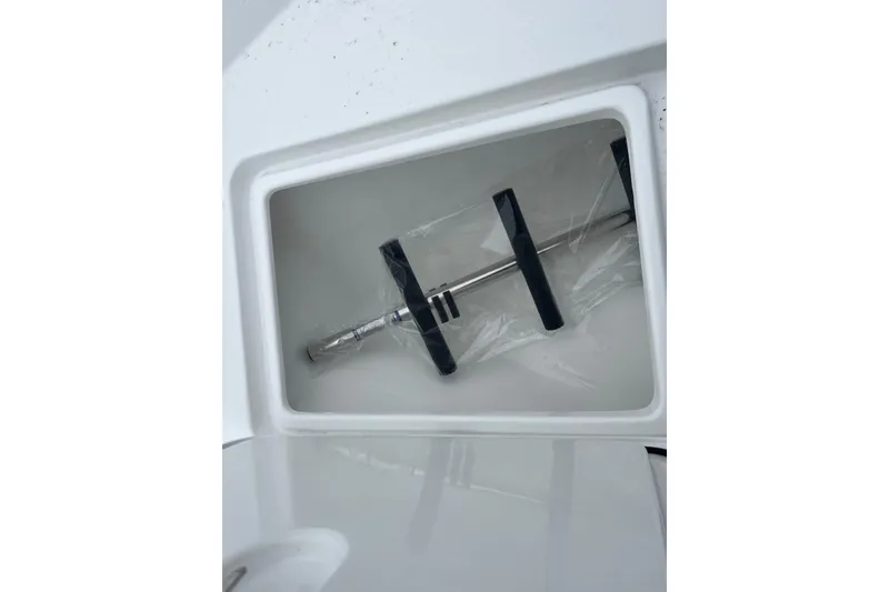 Slide: The Image of Storage compartment in 2026 Cape Horn 22 OS boat, featuring a metal tool with black handles. - 12
