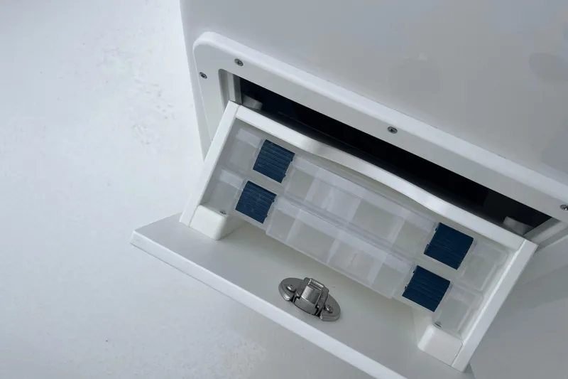 Slide: The Image of Cape Horn 22 OS 2026 boat compartment with storage drawer and latch. - 14