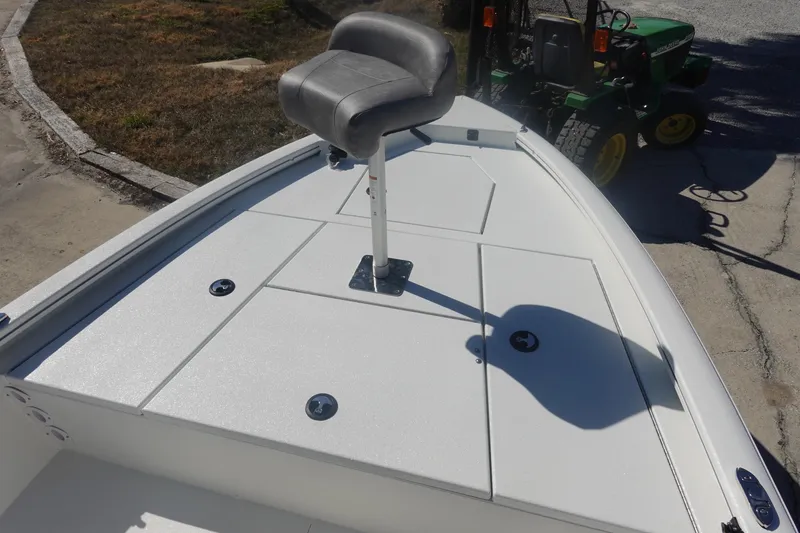 Slide: The Image of 2026 Avid 19 FSX boat deck with seat, parked near a green tractor. - 25