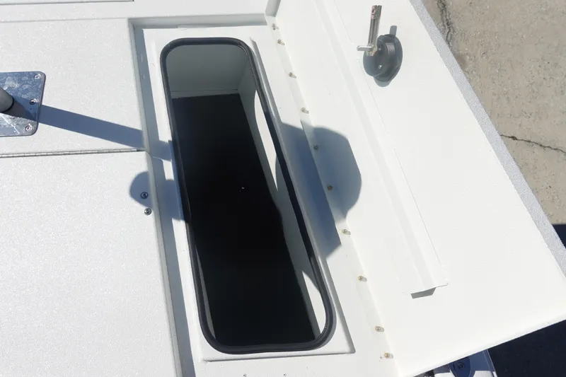 Slide: The Image of Open storage compartment on 2026 Avid 19 FSX boat, featuring a sleek white design. - 27